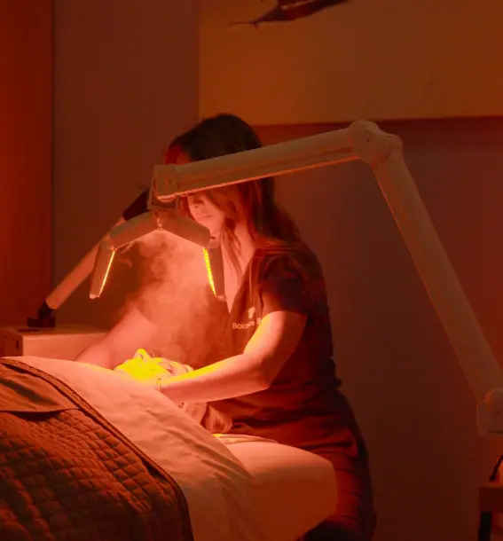 Facial Specialist peforming facial using LED Facial Treatment Device