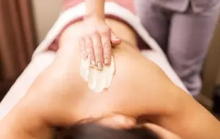 Person getting a massage with massage cream on their back