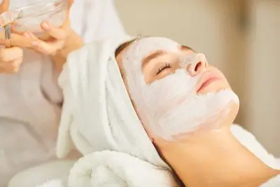 Relaxed spa client with facial mask applied