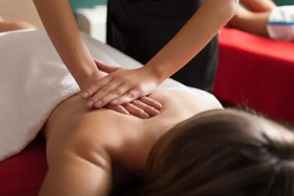 Massage therapist using Swedish massage techniques to relax the client.