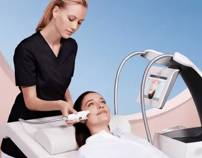Specialist applying Face Endermologie device to a woman's cheekbones